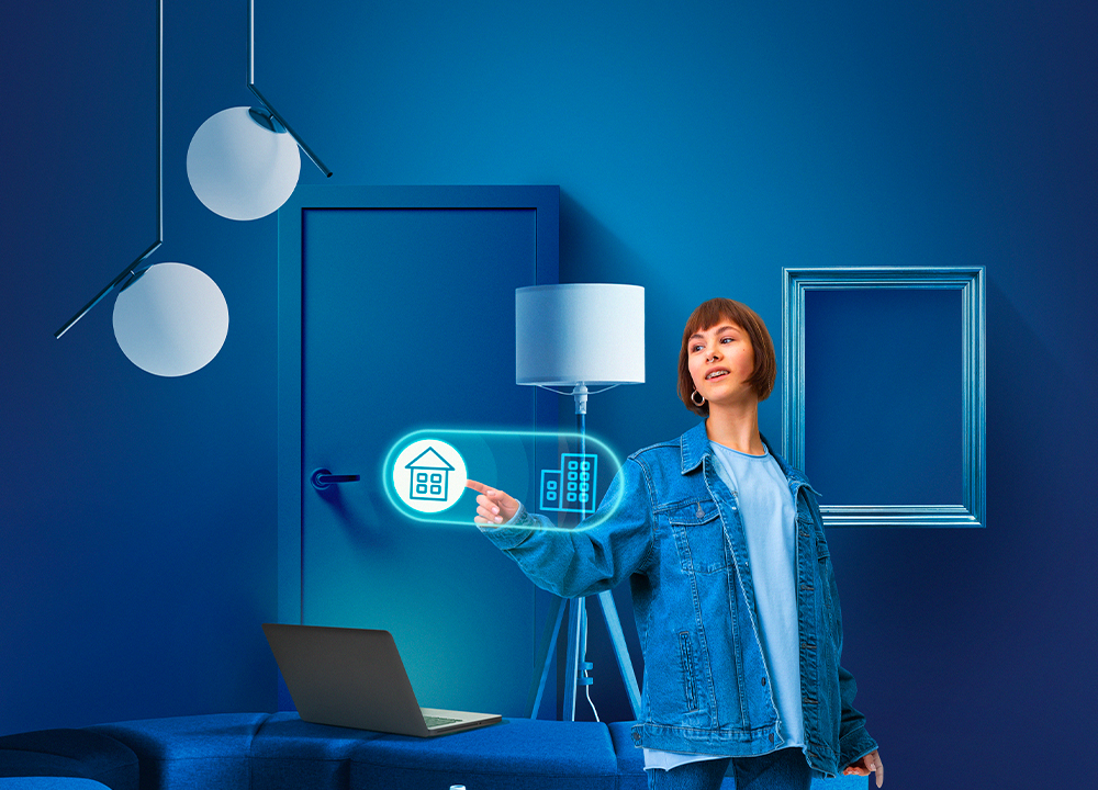 Donna in una casa domotica che gestisce l’illuminazione e la sicurezza tramite controllo digitale