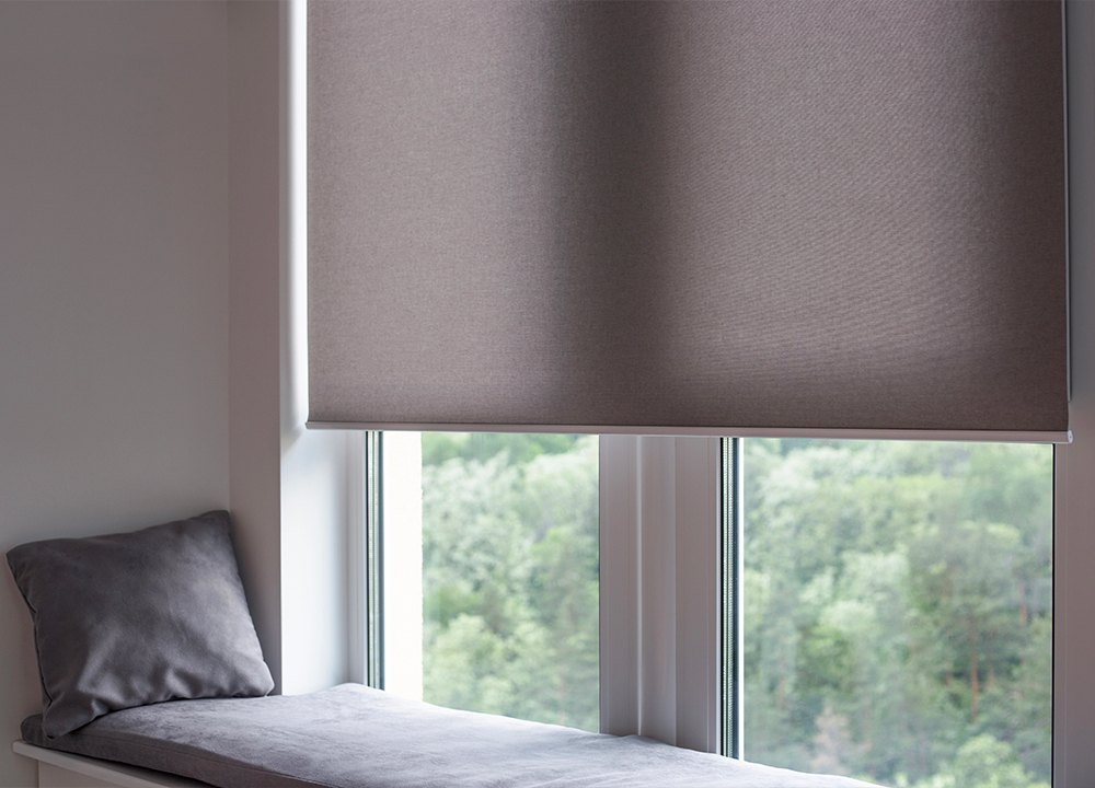 Finestra moderna con tende a rullo automatizzate integrate in un sistema domotico