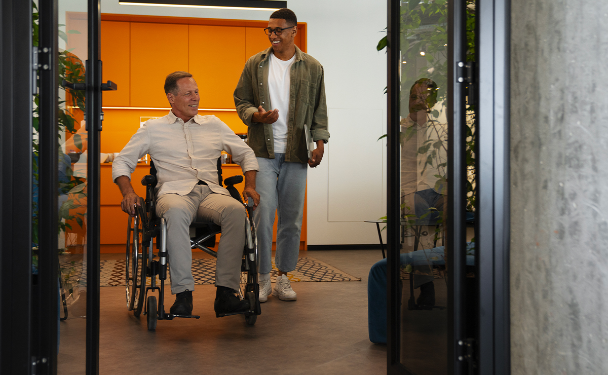 Uomo in sedia a rotelle che attraversa una soglia con infissi accessibili